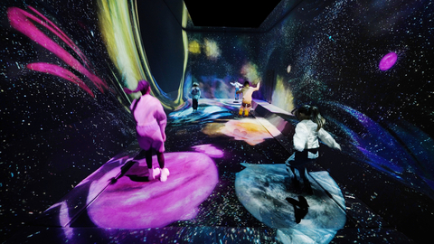 teamLab，多维弹跳宇宙 (c) teamLab - “多维弹跳”是一个柔性表面，游客可以在上面跳跃，体验下沉或比平时跳得更高的感觉。当你站在“多维弹跳”上时，脚下的表面会下沉，从而产生时空扭曲。这种扭曲会吸引宇宙中的星尘，诞生新的恒星。当你跳到一颗恒星上时，它就会开始移动，当你在恒星上不断跳跃时，它就会成长，你便能体验到恒星的整个生命周期。