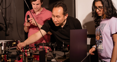 Boston University College of Engineering Associate Professor Jerry Chen, center, with senior scientist Andrew Blaeser to the left, and former undergraduate research assistant Rhea Singh to the right, working with a Quadroscope, a custom, two-photon mesoscope. Credit: Christopher McIntosh.